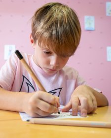 A child drawing at a table