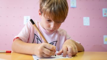 A child drawing at a table