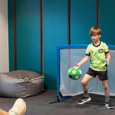 Children playing indoor soccer in front of a goal Children playing indoor soccer in front of a goal