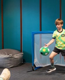 Children playing indoor soccer in front of a goal Children playing indoor soccer in front of a goal