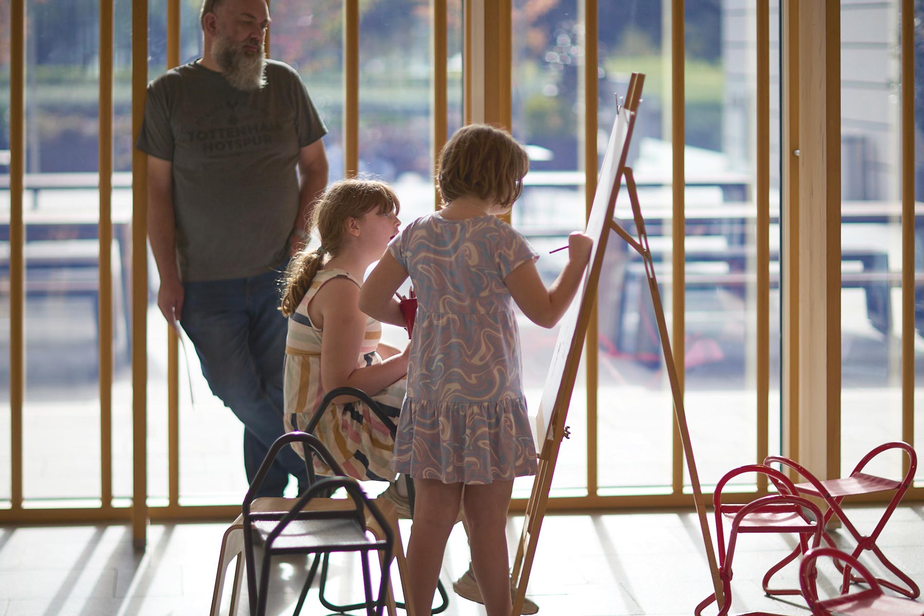 Two children drawing at an easel in the Gordon Darling Hall
