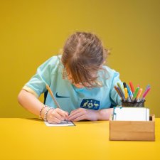 A child drawing at a yellow table A child drawing at a yellow table