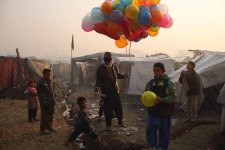 At sunrise, a balloon seller makes his way through an informal settlement for families displaced by fighting in Afghanistan’s provinces, beside Kabul’s national cricket stadium, 2014 Andrew Quilty