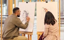 Two people drawing at easels