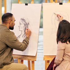 Two people drawing at easels
