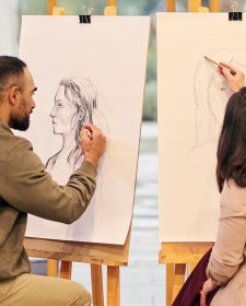 Two people drawing at easels