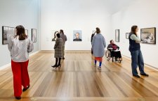 People viewing artworks in a gallery People viewing artworks in a gallery