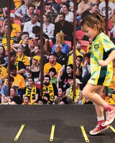 A child running in front of a large audience A child running in front of a large audience
