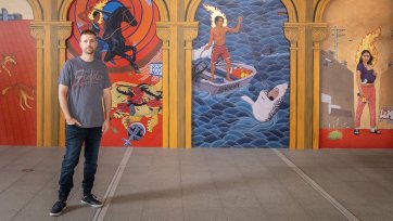 Ryan Presley in front of his artwork Paradise won