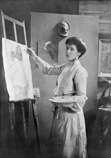 Portrait of Frances Mary Hodgkins painting at an easel in her studio in Bowen Street