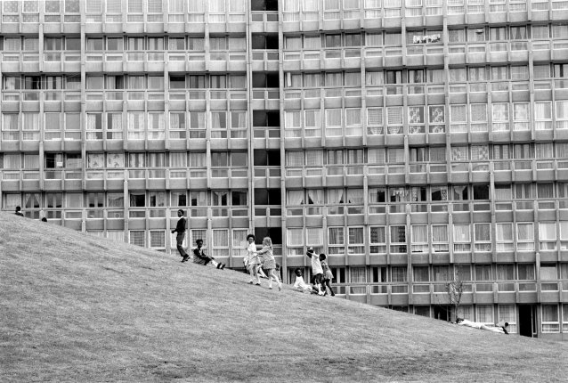 Children playing in front of the stark backdrop of Robin Hood Gardens – a residential estate in Poplar, London, designed by Alison and Peter Smithson (completed 1972)