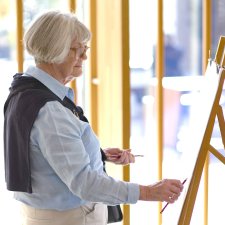 A person drawing with a pencil at an easel
