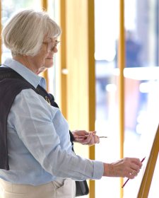 A person drawing with a pencil at an easel