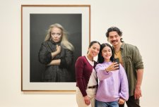 People using a phone to take a photo in front of an artwork