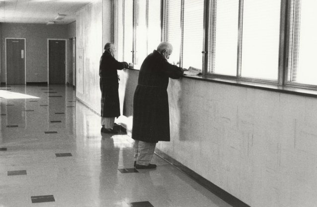 Two older men reading at window, 1979