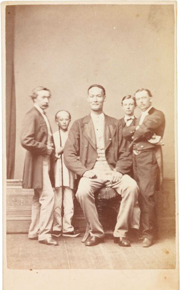 Chang the Chinese giant in European dress with Chinese boy and three European men, one of whom is his manager