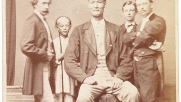 Chang the Chinese giant in European dress with Chinese boy and three European men, one of whom is his manager