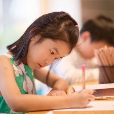 A child drawing at a wooden table A child drawing at a wooden table