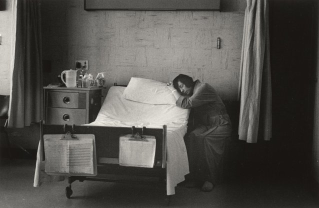 Woman patient next to bed asleep on pillow, 1979