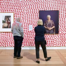 Two people viewing artworks in the In Bloom exhibition