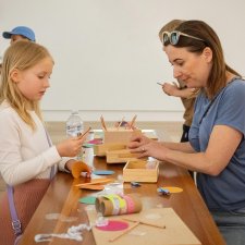 Parents and children at a table with craft activities Parents and children at a table with craft activities